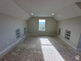 Additional living space featuring lofted ceiling, built in features, and baseboards