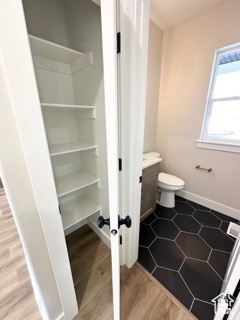 Bathroom with baseboards, wood finished floors, toilet, and vanity