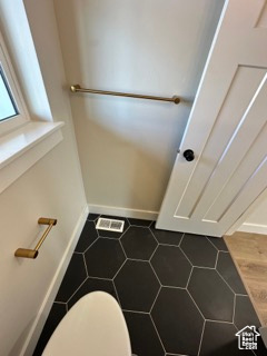 Bathroom featuring baseboards, visible vents, and toilet