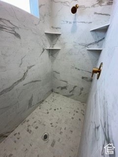 Bathroom featuring a marble finish shower