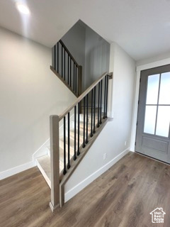 Doorway to outside with stairway, wood finished floors, and baseboards