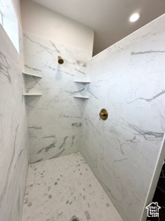Bathroom with recessed lighting and a marble finish shower