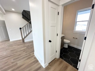 Bathroom featuring wood finished floors, toilet, recessed lighting, and baseboards
