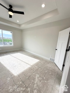 Spare room with baseboards, recessed lighting, a raised ceiling, and ceiling fan