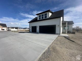 View of home's exterior with driveway, stucco siding, and an attached garage