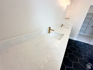 Full bathroom featuring double vanity and a sink