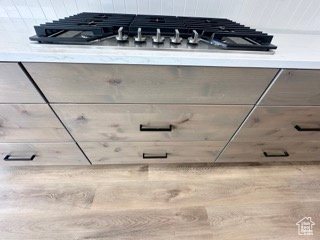 Details featuring gray cabinetry, light countertops, and stainless steel gas cooktop