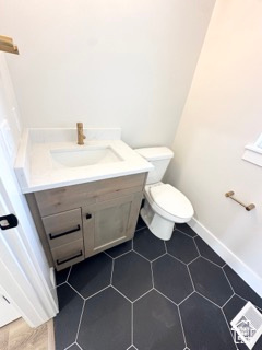Bathroom featuring vanity, toilet, visible vents, baseboards, and tile patterned flooring
