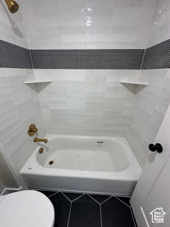 Bathroom with tile patterned floors and toilet