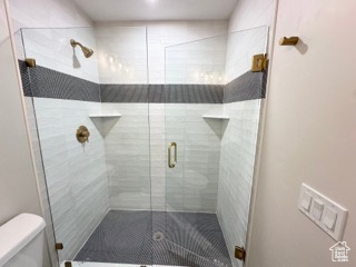 Bathroom with a shower stall and toilet