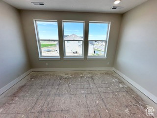 Unfurnished room featuring visible vents and baseboards