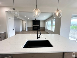Kitchen with light stone counters, open floor plan, a healthy amount of sunlight, and a sink
