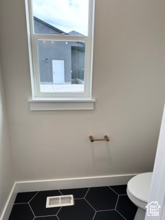 Bathroom featuring visible vents, plenty of natural light, and baseboards
