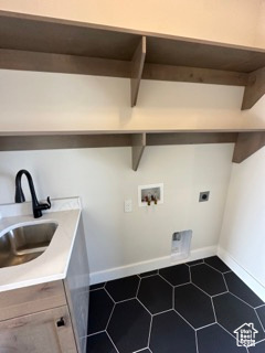 Clothes washing area featuring a sink, electric dryer hookup, hookup for a washing machine, dark tile patterned flooring, and laundry area