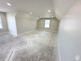 Additional living space with lofted ceiling, recessed lighting, and baseboards