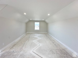 Additional living space with baseboards, recessed lighting, and vaulted ceiling