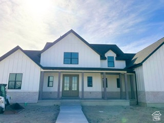 Modern farmhouse style home featuring covered porch, french doors, and board and batten siding