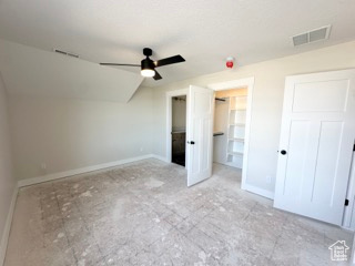 Unfurnished bedroom with visible vents, vaulted ceiling, and baseboards