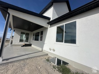 Rear view of house featuring stucco siding and a patio area