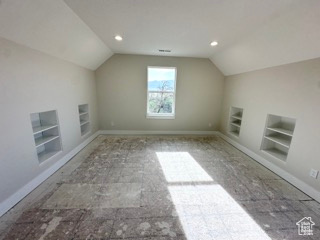 Additional living space with lofted ceiling, baseboards, recessed lighting, and built in shelves