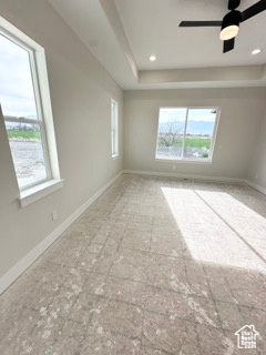 Unfurnished room with a raised ceiling and baseboards