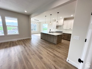 Kitchen featuring open floor plan, wood finished floors, and baseboards