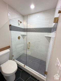 Full bath with toilet, recessed lighting, a shower stall, and tile patterned floors