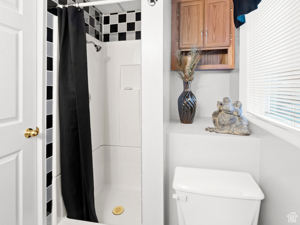 Bathroom featuring toilet and a stall shower