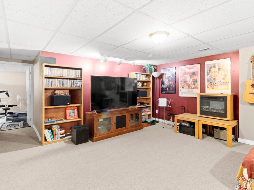 Living room featuring carpet, rail lighting, baseboards, visible vents, and a paneled ceiling