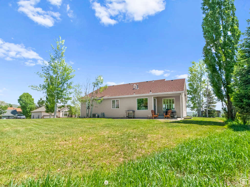Back of property featuring a lawn and a patio