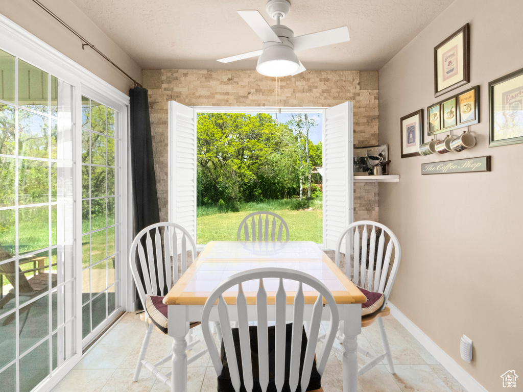 Dining space featuring baseboards, a ceiling fan, and a textured ceiling