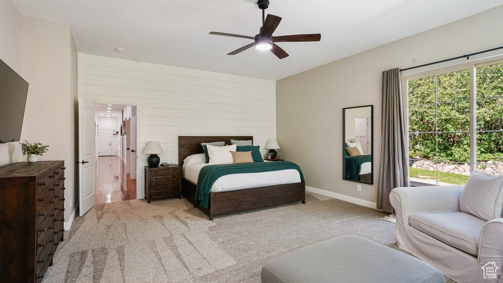Carpeted bedroom with ensuite bath and ceiling fan