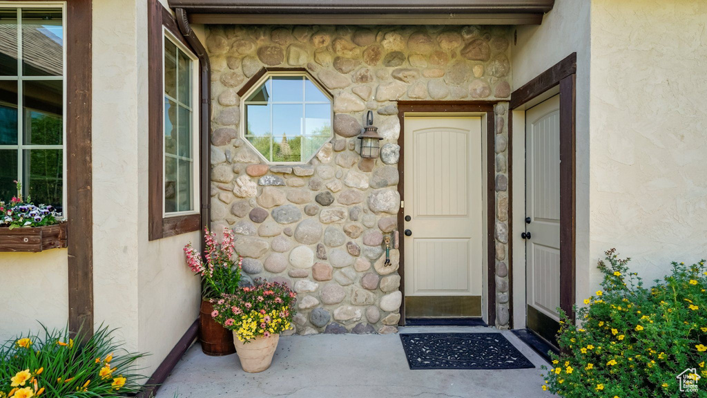 View of exterior entry featuring stone siding and stucco siding