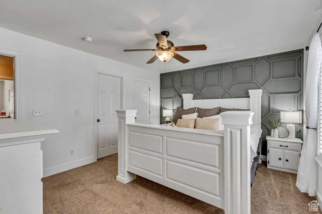 Bedroom with a ceiling fan, baseboards, and light colored carpet