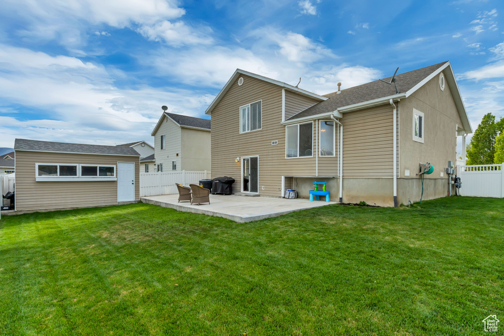 Back of property with a lawn, a patio area, and a fenced backyard