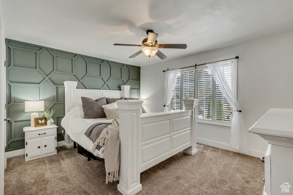 Bedroom featuring a ceiling fan, baseboards, and light carpet