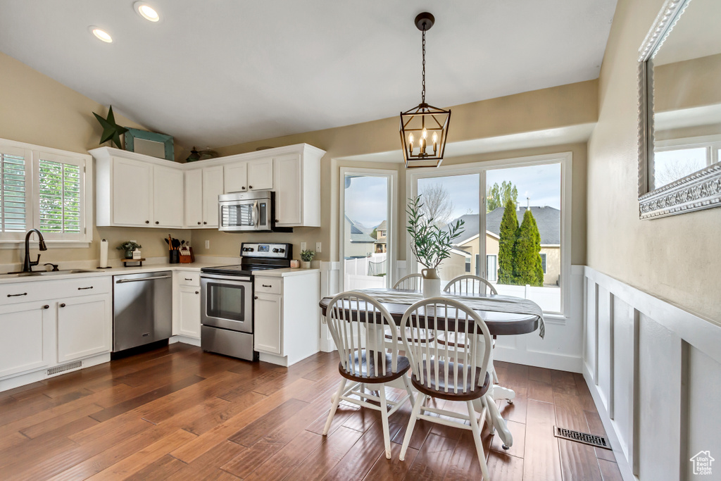 Kitchen with a sink, visible vents, an inviting chandelier, light countertops, and appliances with stainless steel finishes
