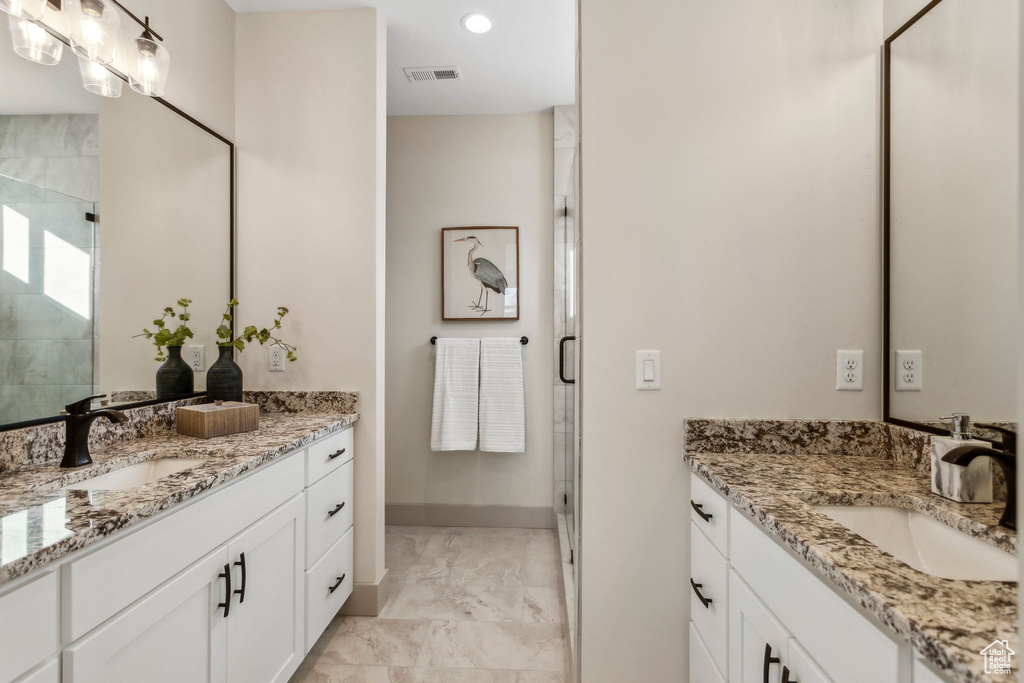 Bathroom featuring marble finish floor, a sink, and a shower stall
