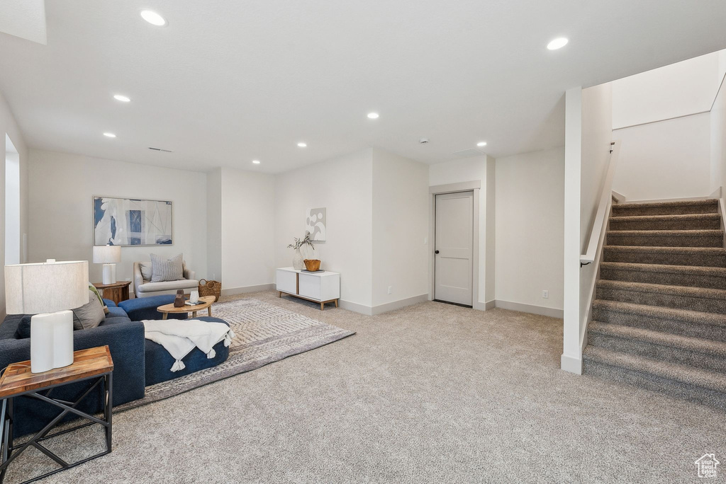 Living area featuring recessed lighting, stairway, light carpet, and baseboards