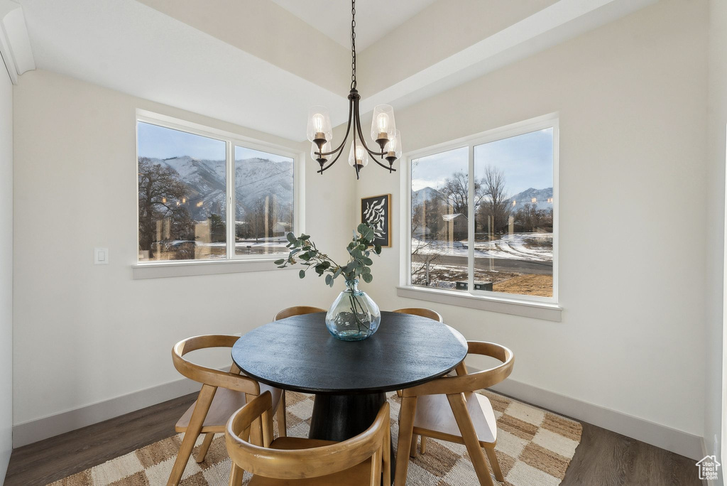 Dining room with baseboards, wood finished floors, a notable chandelier, and a mountain view