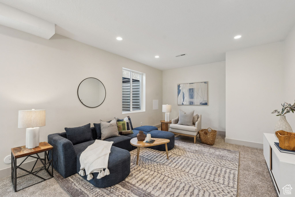 Carpeted living room featuring recessed lighting, visible vents, and baseboards