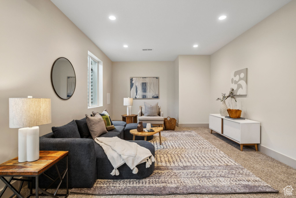 Living room with baseboards, recessed lighting, visible vents, and light colored carpet