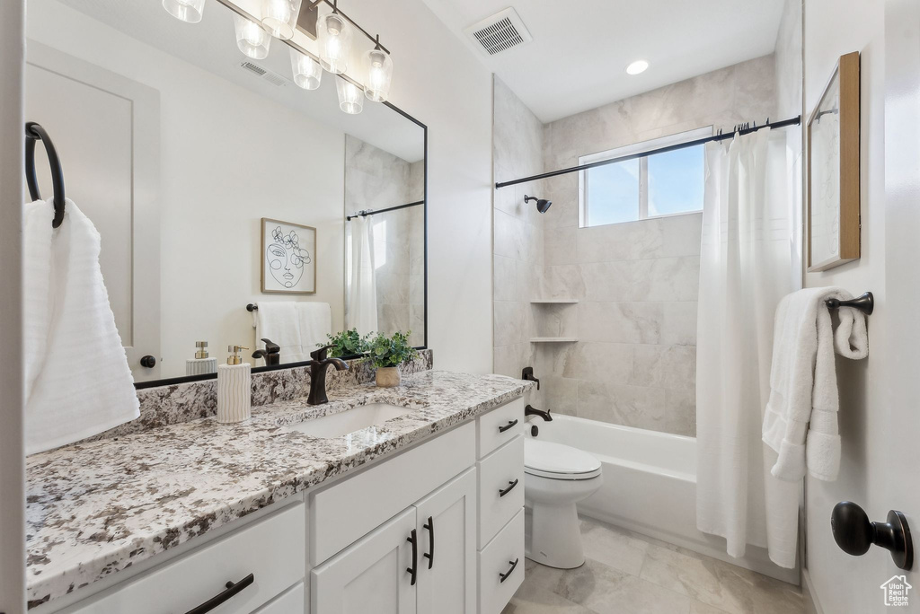 Full bath with vanity, toilet, marble finish floor, visible vents, and shower / tub combo with curtain