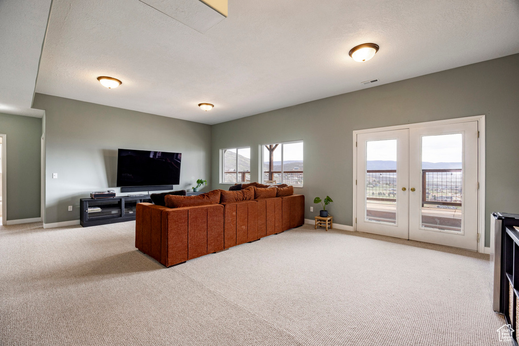 Living room featuring light carpet, french doors, and baseboards