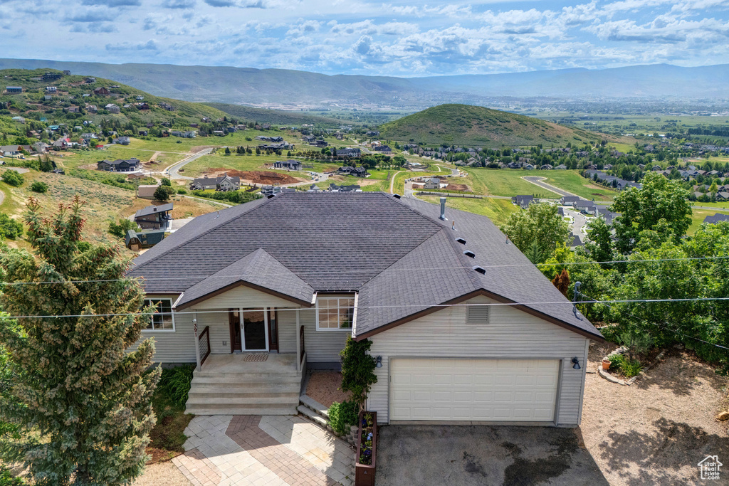 View of front of property with roof with shingles, a mountain view, a garage, and driveway