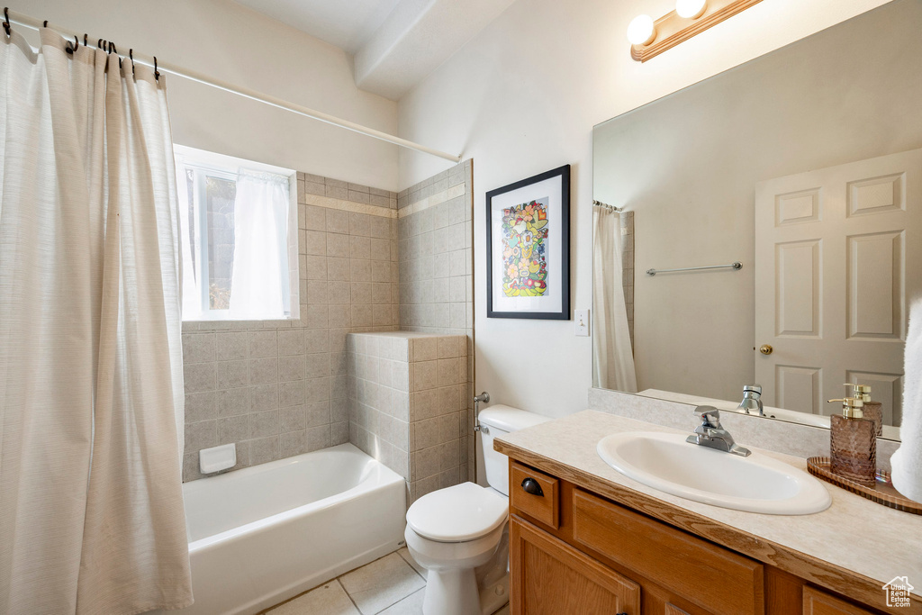 Full bath with toilet, vanity, shower / bath combo with shower curtain, and tile patterned flooring