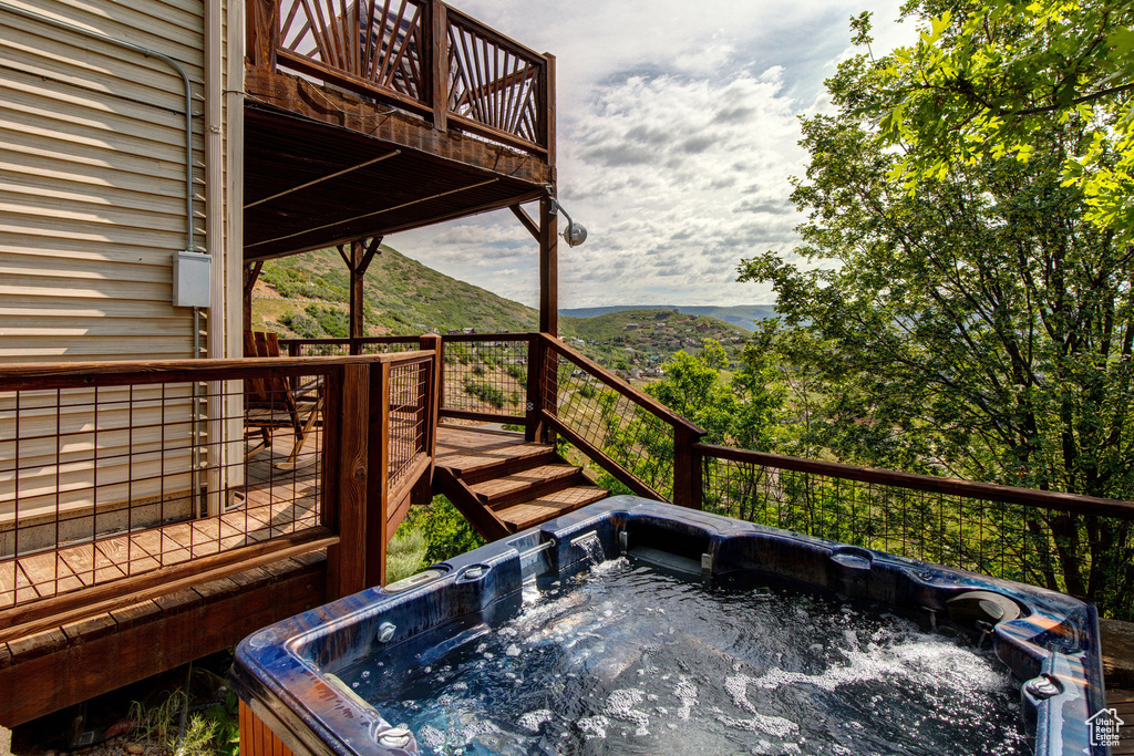 Deck featuring a hot tub and a mountain view