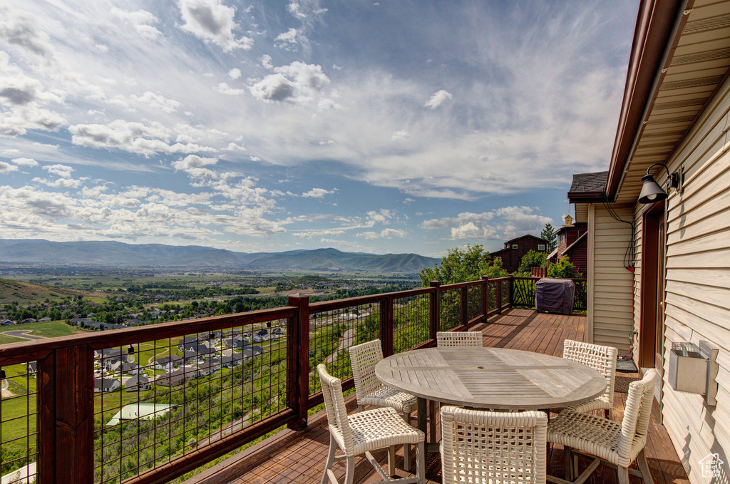 Wooden deck featuring a mountain view and outdoor dining area
