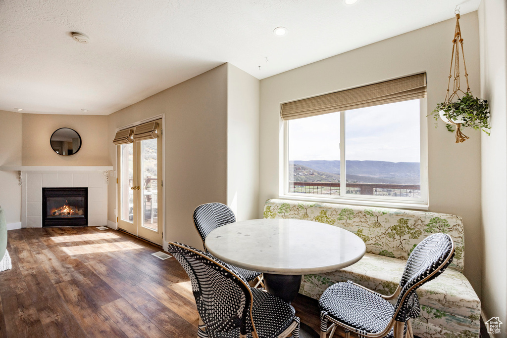 Dining room featuring wood finished floors, a fireplace, recessed lighting, and a mountain view