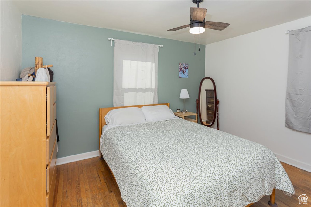 Bedroom featuring wood finished floors, a ceiling fan, and baseboards
